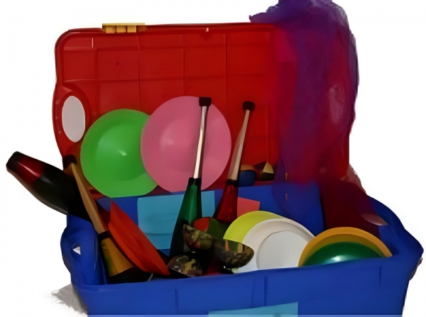Offener Koffer aus Kunststoff mit verschiedenen Jonglierutensilien. Darin liegen Jonglierkeulen, bunte Jonglierteller mit passenden Stäben, Tücher und Bälle. Die Gegenstände sind farbenfroh und aus Kunststoff oder Stoff gefertigt. 